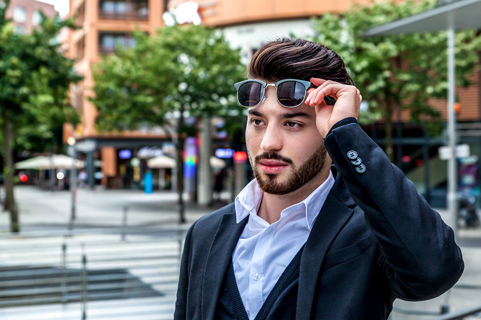 Hautbearbeitung Hautbildverfeinerung, Betonen der Person und Entfernung störender Elemente. Evren steht auf dem Potsdamer Platz. Bäume im Hintergrund.