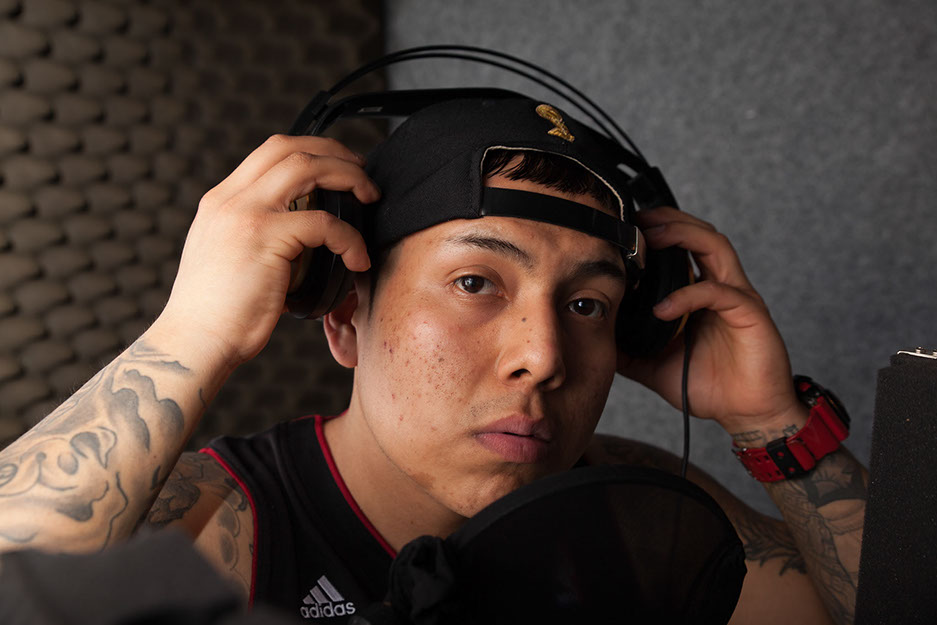 Shooting im Tonstudio  Shooting im Tonstudio. Person steht am Mirkophone und nimmt seine Kopfhörer ab. Vor der Bildbearbeitung.